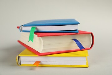 Books with colorful tabs on light gray background, closeup