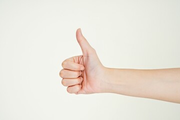 hand giving a thumbs up gesture, signifying positivity, approval, and agreement, isolated over...