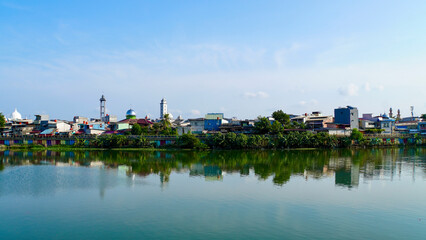 Fototapeta premium The calm waters at Sunter Lake in Jakarta, Indonesia. The calm waters reflect the vast blue sky above