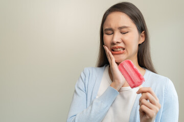 Face expression suffering from sensitive teeth, Asian young woman touching cheek
