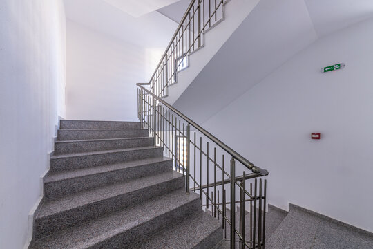 Modern stair case between floors. Stairs with metallic rail in modern building