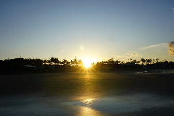 Sunrise on the beach. Sun and warm morning light on the beach with black sand background. Natural...
