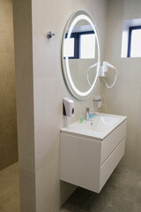 Beautiful mirror with backlight above the sink in the toilet of a country house
