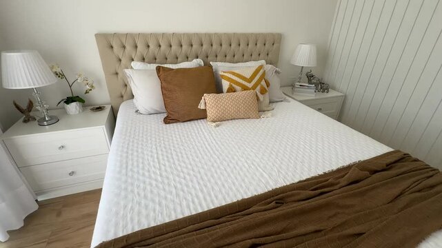 cama arrumada com cabeceira de luxo capitone e tons decora&ccedil;&atilde;o amarela e tons marrons 