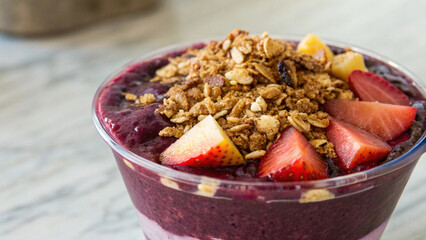 Fototapeta premium vibrant smoothie bowl topped with granola and fresh strawberries, perfect for healthy snack