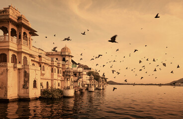 Pigeons flying over City Palace at Pichola lake in Udaipur, Rajasthan, India