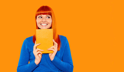 Bright colored background highlights a smiling woman holding a book in a cozy indoor setting during...