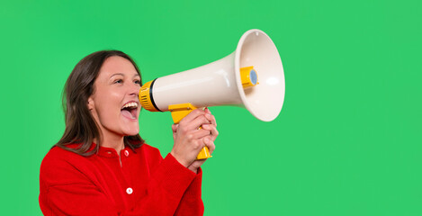 Excited woman with megaphone engaging an audience against a green background during a lively event