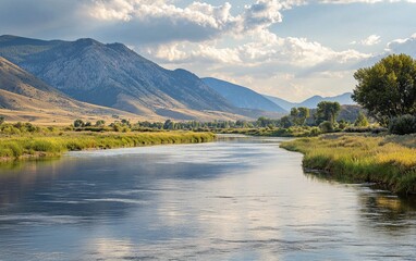 Obraz premium A scenic view of a calm river flowing through a valley with mountains in the distance