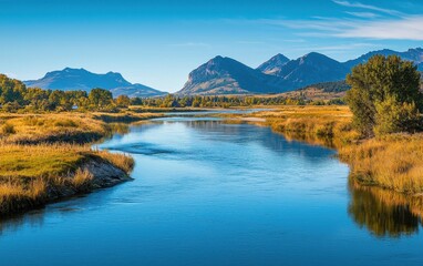 A scenic view of a calm river flowing through a valley with mountains in the distance