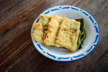 Close up of Tempe (fried soybean cake), on a classic plate. Indonesian traditional food.