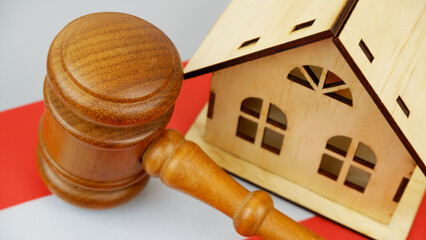 Law and real estate business in Austria. Gavel with wooden house on Austrian flag.