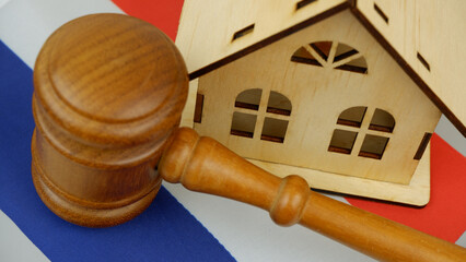 Law and real estate business in Netherlands. Gavel with wooden house on Dutch flag.