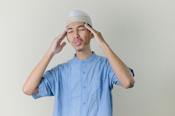 asian moslem man feeling headache isolated in white background