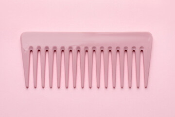One plastic hair comb on pink background, top view