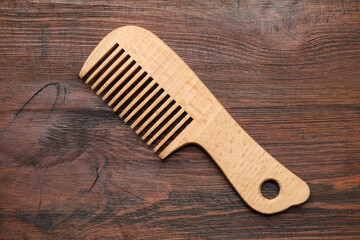 One hair comb on wooden background, top view