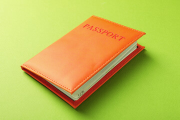 Passport in orange cover on green background, closeup