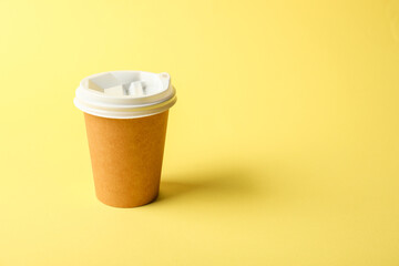 One paper cup on yellow background. Mockup for design
