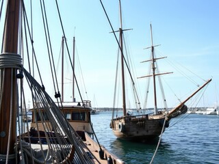 Masts and ropes of a long-abandoned ship in the harbor, shipwreck, wooden, seafaring