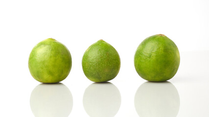 Limes Isolated in White Background Showcasing Three Green Fruits Arranged Linearly