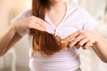 Teenage girl brushing her hair at home, closeup