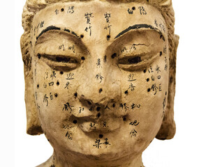 Ancient wooden female face showing acupuncture points and the name, isolated on white background