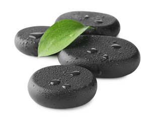 Wet spa stones and green leaf isolated on white