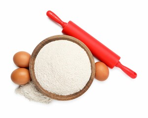 Rolling pin, eggs and flour isolated on white, top view