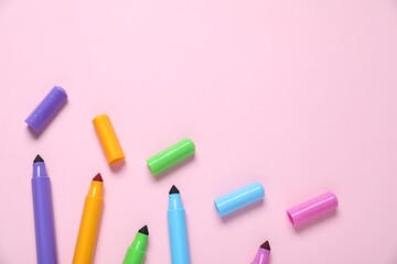 Many colorful markers on pink background, flat lay. Space for text