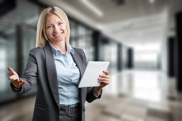 Smiling young businesswoman using digital tablet at work.