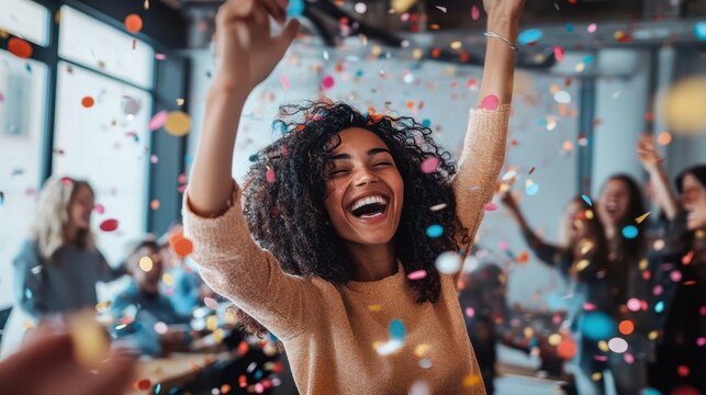 A multiethnic startup business team celebrating success with confetti in the office.