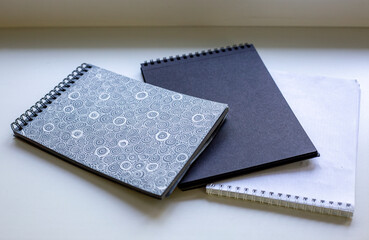 Spiral-bound sketchbooks on white surface. 
