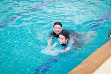 Grandmother and granddaughter exercising and swimming in the pool. Hydrotherapy. Physical therapy treatment.