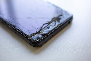 Close-up of a smartphone with a severely cracked screen. 
