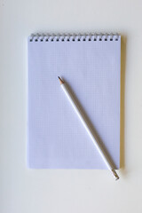 White pencil on spiral notepad with graph paper. 