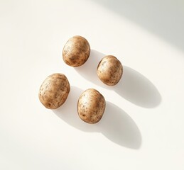 Fototapeta premium Fresh organic potatoes on white background with soft shadows highlighting their natural texture and earthy tones in a minimalist style composition