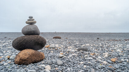 View of a pyramid made of stack of round stones put together at each other at stony gravel beach...