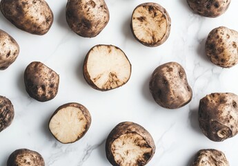 Fototapeta premium Fresh Raw Potatoes Displayed on Marble Surface, Various Shapes and Sizes, Healthy Cooking Ingredient, Natural Food Background for Culinary Use