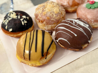 Naklejka premium Traditional german new year pastry berliner donuts deep fried cakes with chocolate and assorted sweet glaze close up