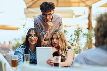 Obraz premium A Diverse MultiEthnic Group Reviewing Projects During a Work Break in a Caffee.