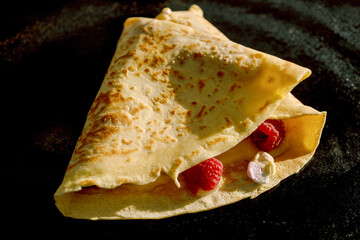 A delicious French crepe, golden and thin, elegantly wrapped around a medley of fresh berries and crunchy nuts, tasty pancake treat generally enjoyed as a decadent breakfast or as a delightful dessert