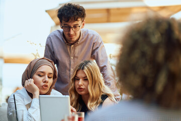 A Diverse MultiEthnic Group Reviewing Projects During a Work Break in a Caffee.