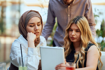 A Diverse MultiEthnic Group Reviewing Projects During a Work Break in a Caffee.