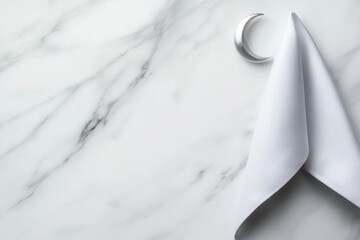 Elegant white napkin draped on a marble surface with a crescent moon decoration