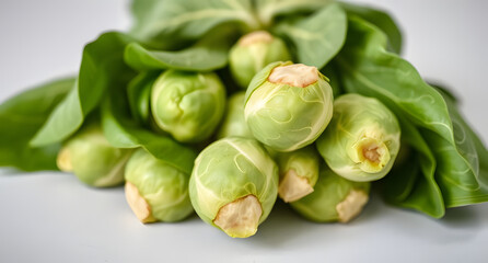 A bunch of fresh Brussels sprouts with vibrant green leaves, resting on a light surface. Nutritious and earthy design