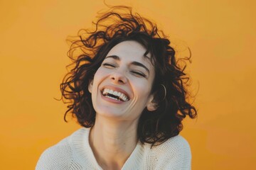Portrait of a glad woman in her 40s laughing isolated on soft orange background