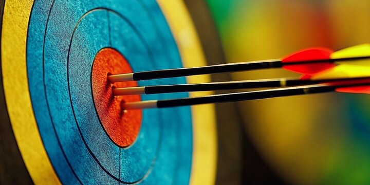 Close up of circular archery target with blue and red colors three arrows in center indoor range setting