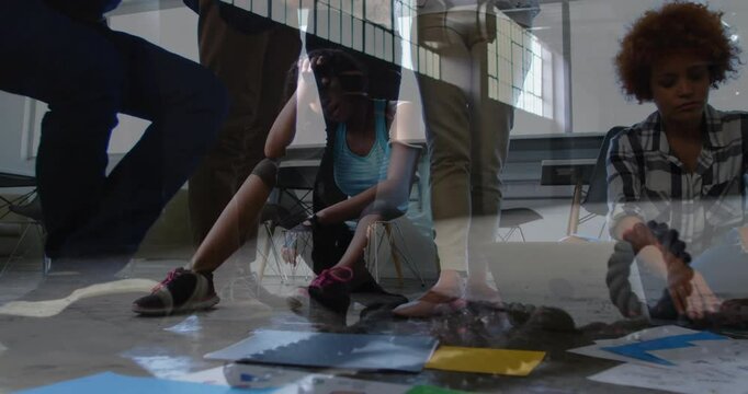 In office, people standing and sitting, papers scattered, discussing animation project