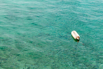 Buoy floating on the clear turquoise water of the Lesser Cyclades, Greece