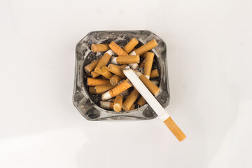 Ashtray butts cigarette on white